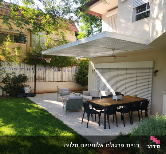 פרגולה מאלומיניום בחצר עם שולחן וכיסאות